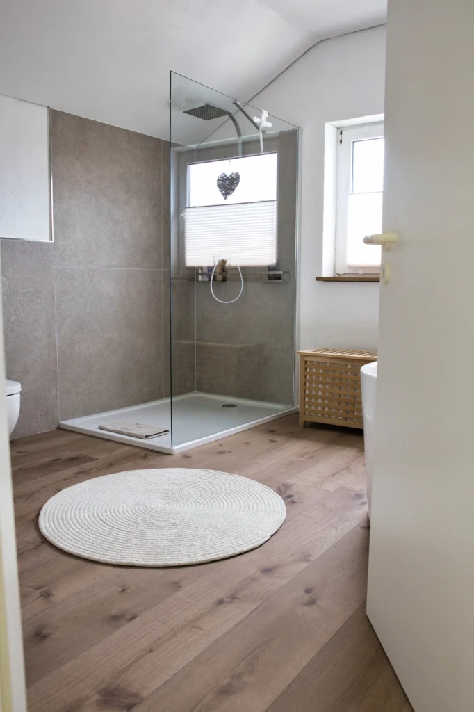 Badezimmer mit Walk-in-Dusche und Holzoptikboden