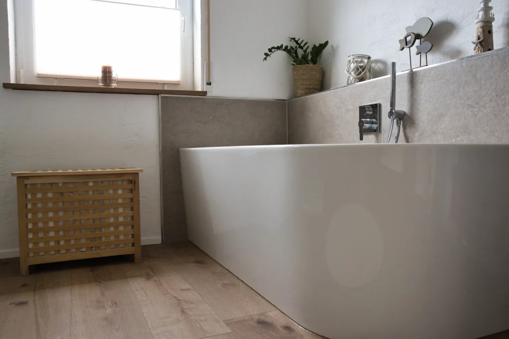 Freistehende Badewanne mit Holzverkleidung und Naturdeko