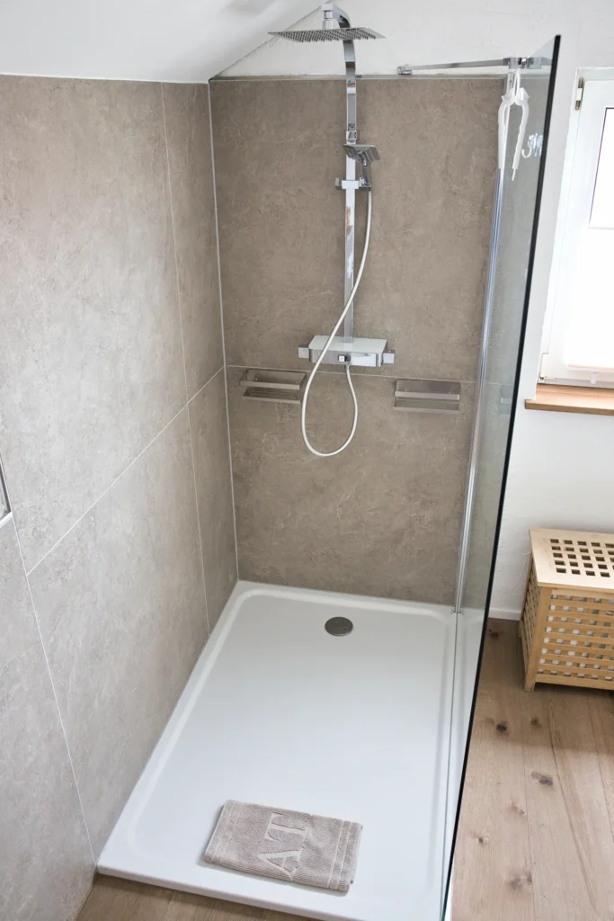 Moderne Dusche mit Regenbrause und Natursteinfliesen