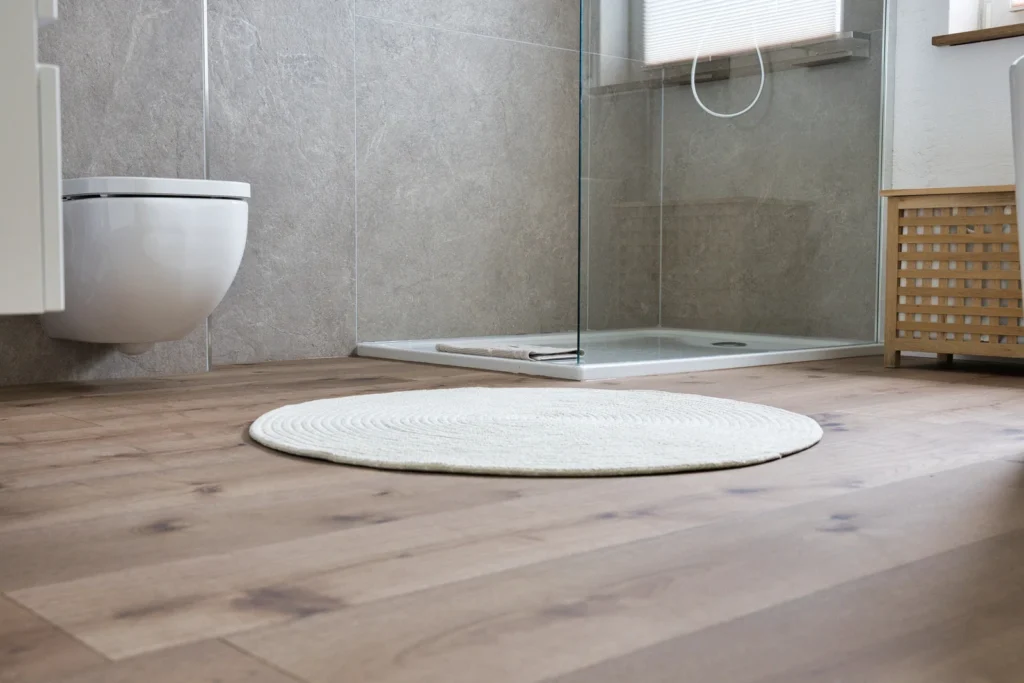 Ebenerdige Dusche und wandhängendes WC auf warmem Holzfußboden