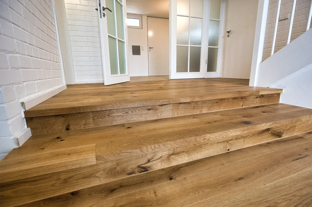 Treppe mit Eichenparkett und weißen Türen im Hintergrund