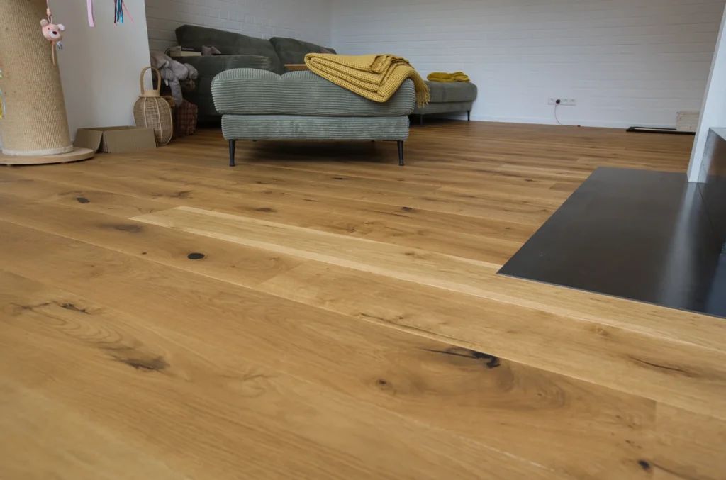 Wohnzimmer mit Eichenparkettboden und grünen Cord-Sofas