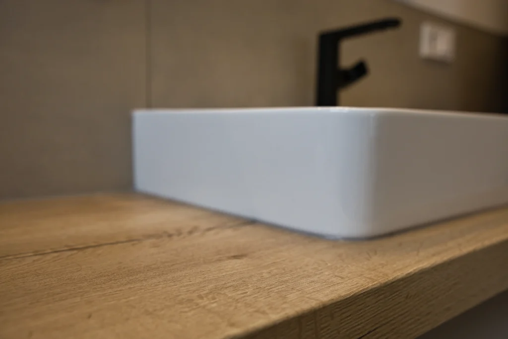 Detailaufnahme eines Aufsatzwaschtischs auf strukturierter Holzplatte – Vatter Badstudio