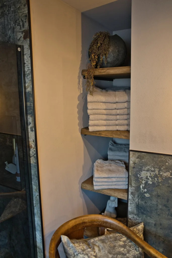 Dekorative Handtuchnische mit Holzregalen und angrenzender Fliesenwand im Bad in Queidersbach