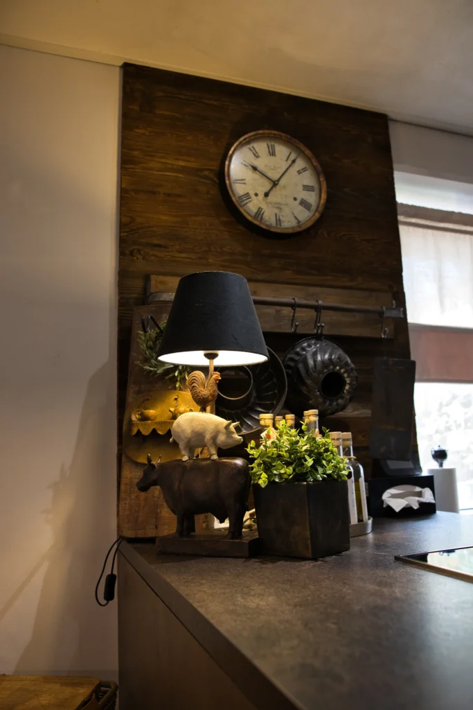 Stimmungsvoll eingerichteter Küchenbereich mit Tierfigurenlampe, Holzverkleidung und Uhr in Queidersbach