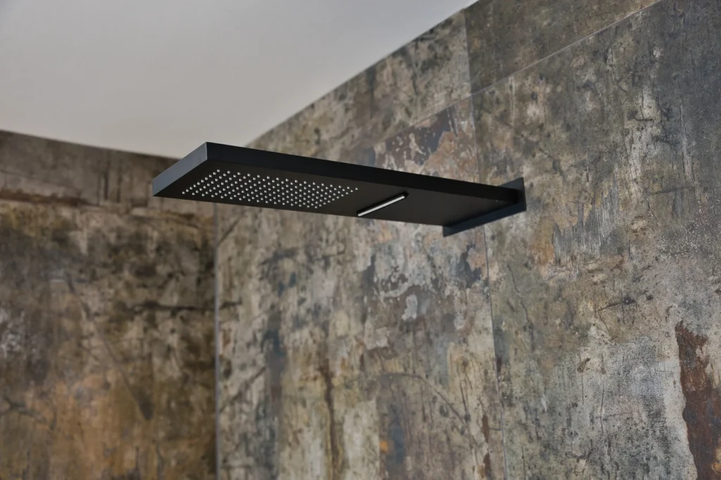 Mattschwarze Regendusche an Fliesenwand mit Used-Look – modernes Duschdesign