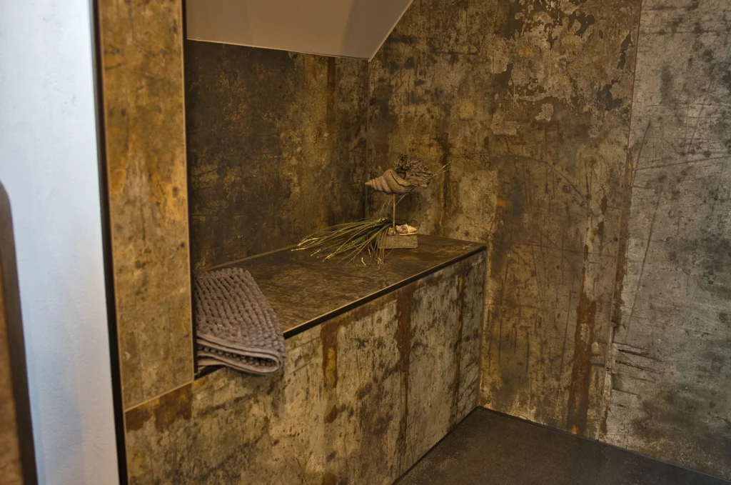 Geflieste Sitzbank in der Dusche mit rostfarbener Oxidoptik – Bad in Queidersbach