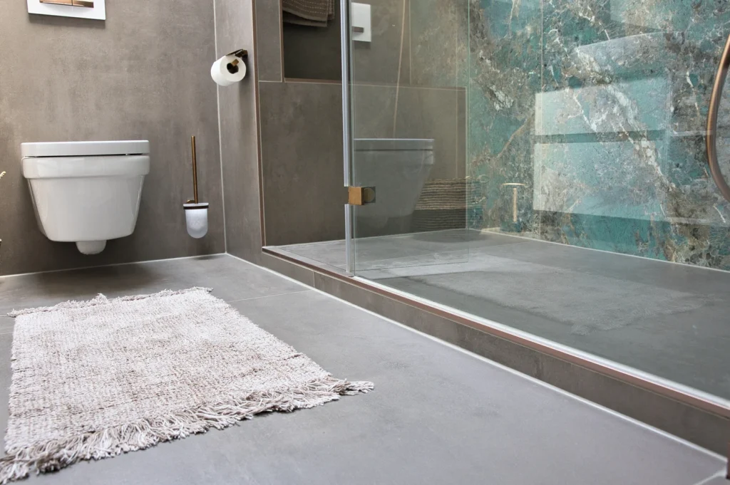 Walk-in-Dusche mit Glasabtrennung und Wandfliesen in Natursteinoptik
