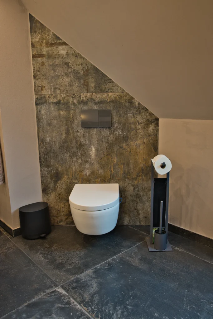 Modernes wandhängendes WC mit Fliesenwand in Oxidoptik im Bad in Queidersbach