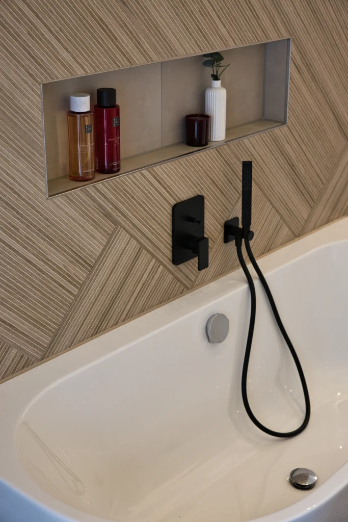 Detailansicht der Wandnische über freistehender Badewanne mit schwarzer Armatur – Vatter Badgestaltung