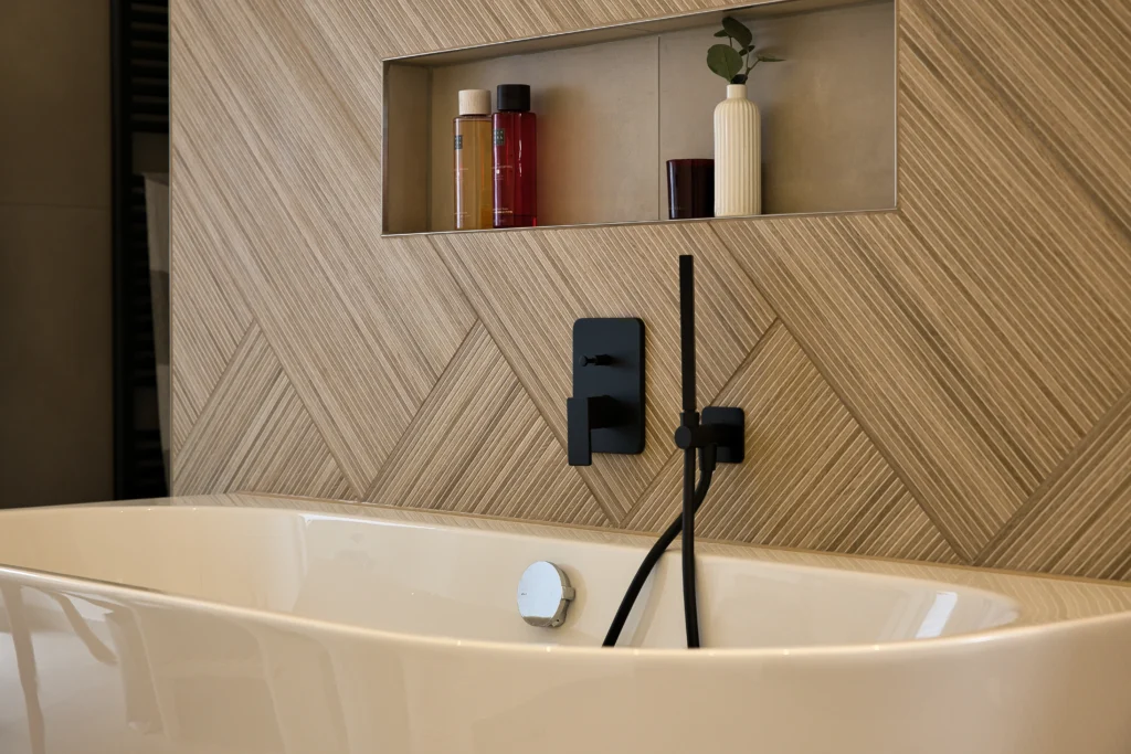 Wandnische über Badewanne mit Holzoptikfliesen und schwarzer Armatur – Vatter Badstudio