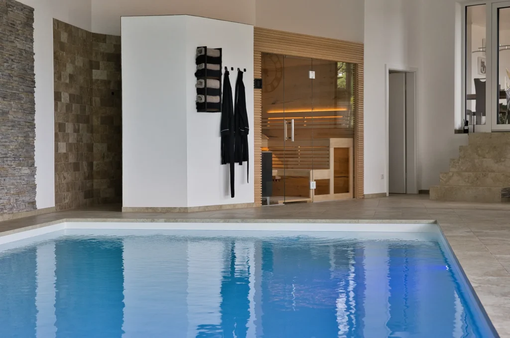 Indoor-Pool mit angrenzender Sauna und Feinsteinzeugfliesen von Century in Krickenbach