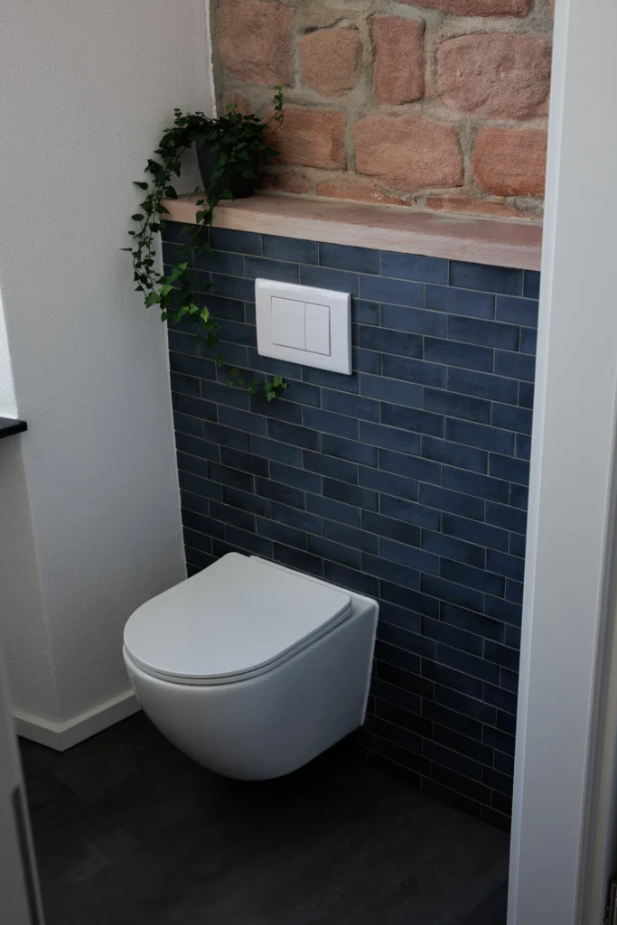 WC-Bereich mit blauen Wandfliesen von Equipe und Natursteinwand