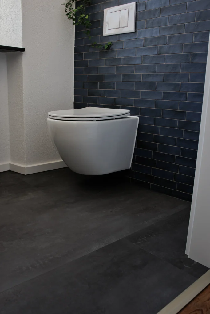 Modernes Gäste-WC mit blauen Wandfliesen von Equipe und dunklem Bodenbelag