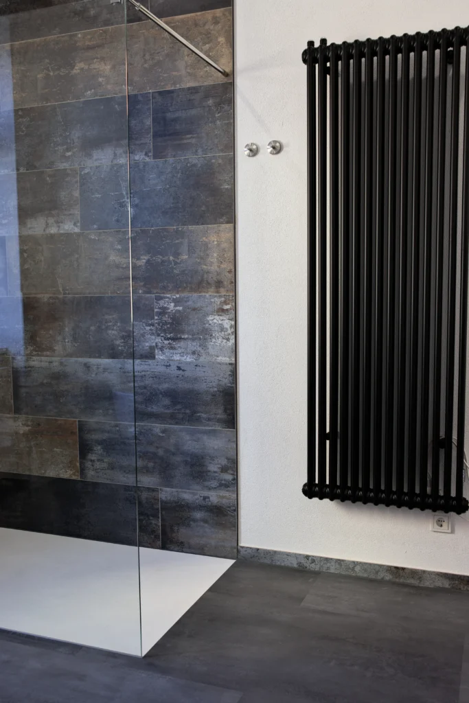 Moderne Dusche mit Glaswand, Fliesendekor-Mix und schwarzem Designheizkörper