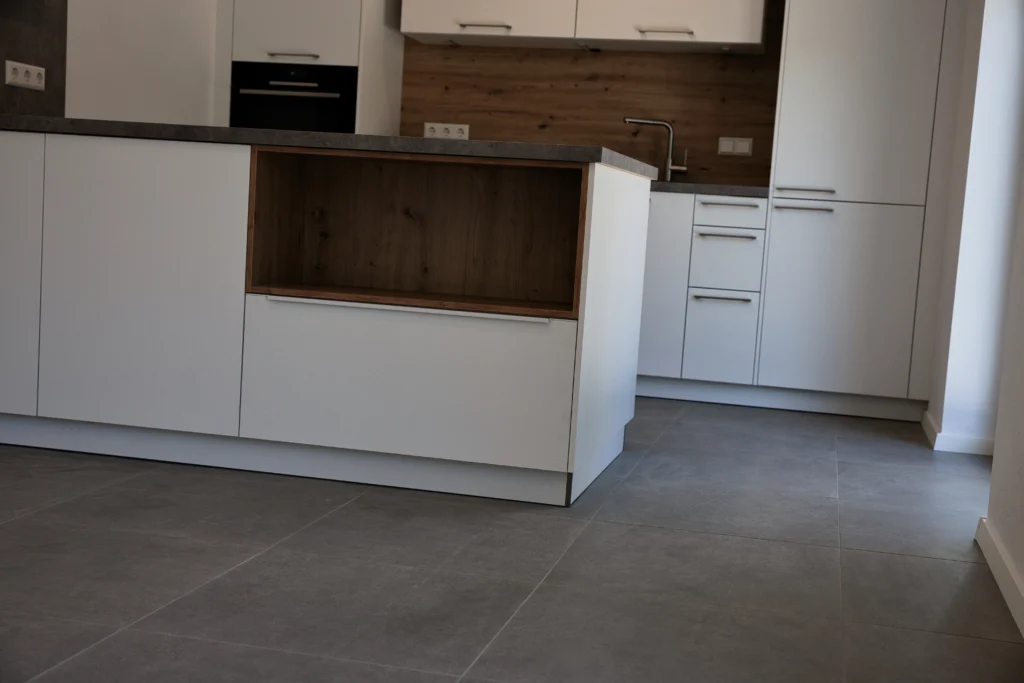 Moderne Küchenzeile mit Holzrückwand und grauen Bodenfliesen