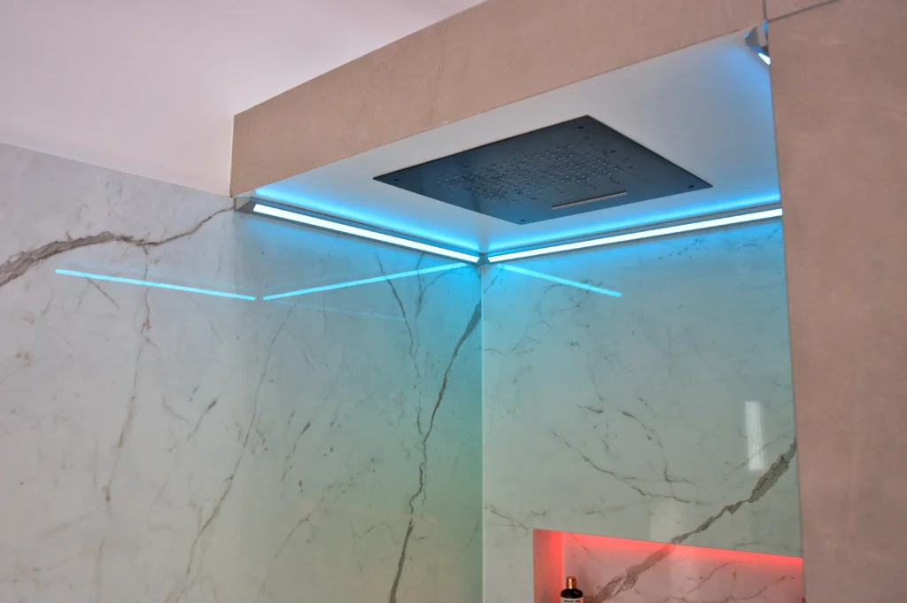 Deckeneinbaubrause mit umlaufenden LED-Lichtlinien und Marmoroptik-Fliesen