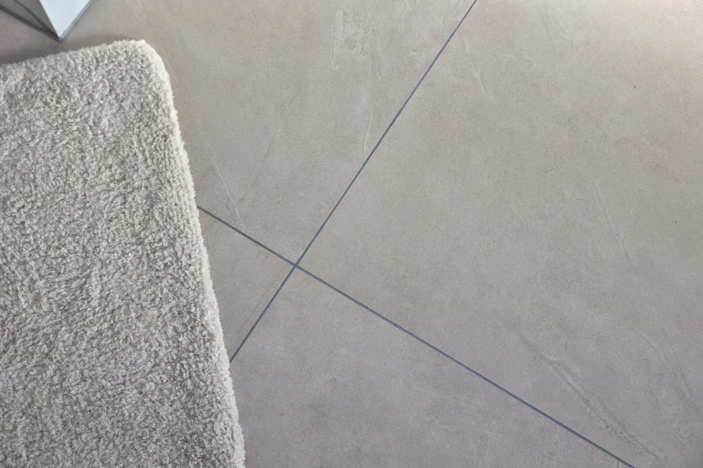 Detailaufnahme Bodenfliese Prism Cord mit feiner Natursteinstruktur und schmalen Fugen im Badezimmer